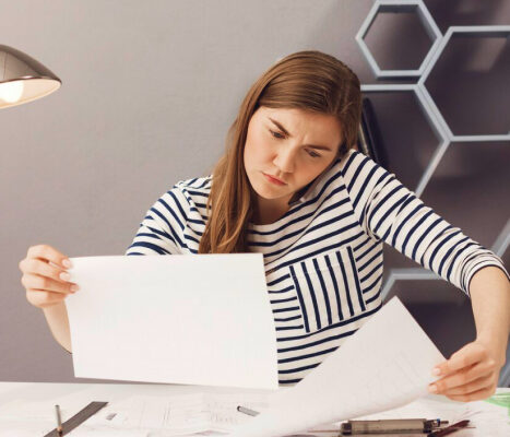 A woman on a phone, with papers, looking busy ready to hear some self care tips for women