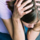 signs of a mentally unstable person featured image with a young woman holding her head