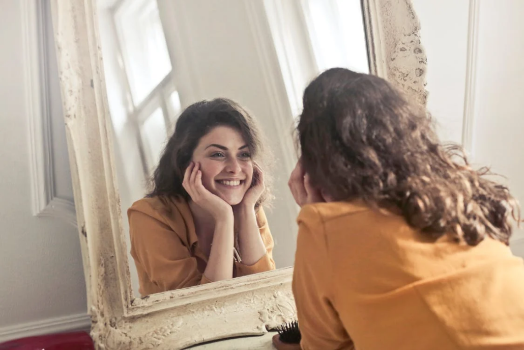 woman looking herself in the mirror