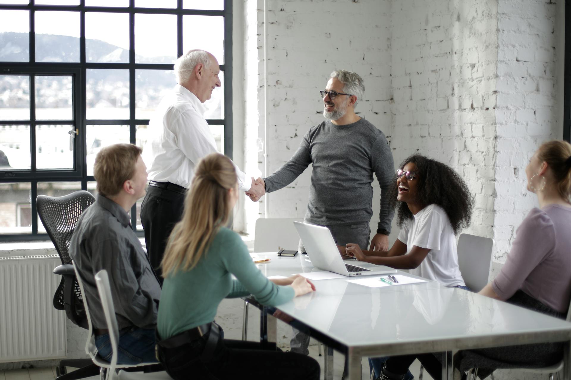 Two men shaking hands in the meeting after talking about returning to work after mental health issues. 