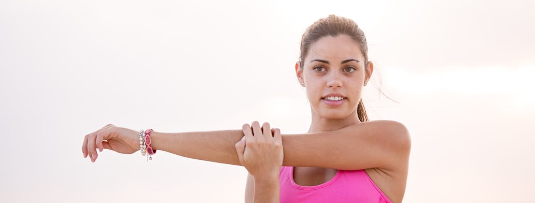 A woman stretching, about to exercise, which is one of the most important self care tips for women