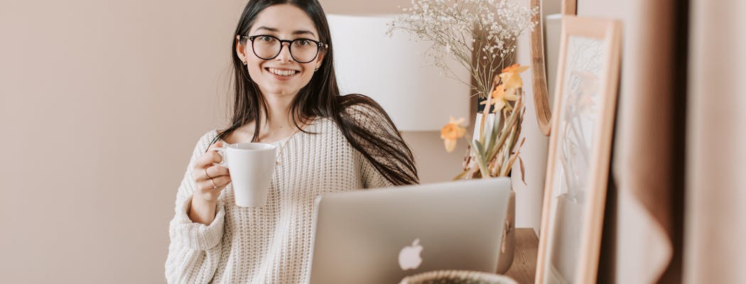 A woman drinking tea while reading tips on self care for women